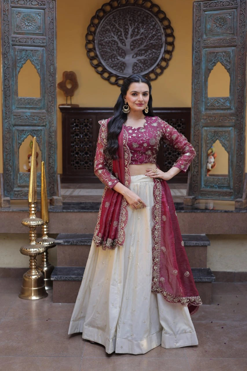 Woman in a traditional outfit standing in a decorated room with ornate wall designs.