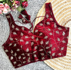 Red embroidered blouse with floral arrangement on a textured surface