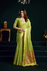 Woman wearing a green saree with floral patterns in a dark setting