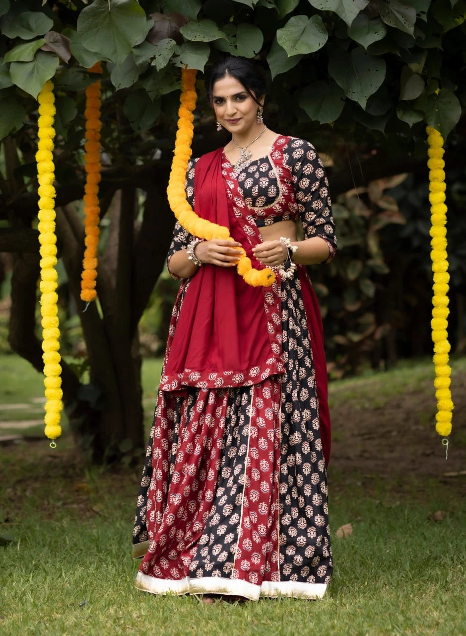 Woman in a traditional outfit standing outdoors with decorative elements.