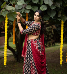 Woman in traditional saree standing outdoors with decorative elements