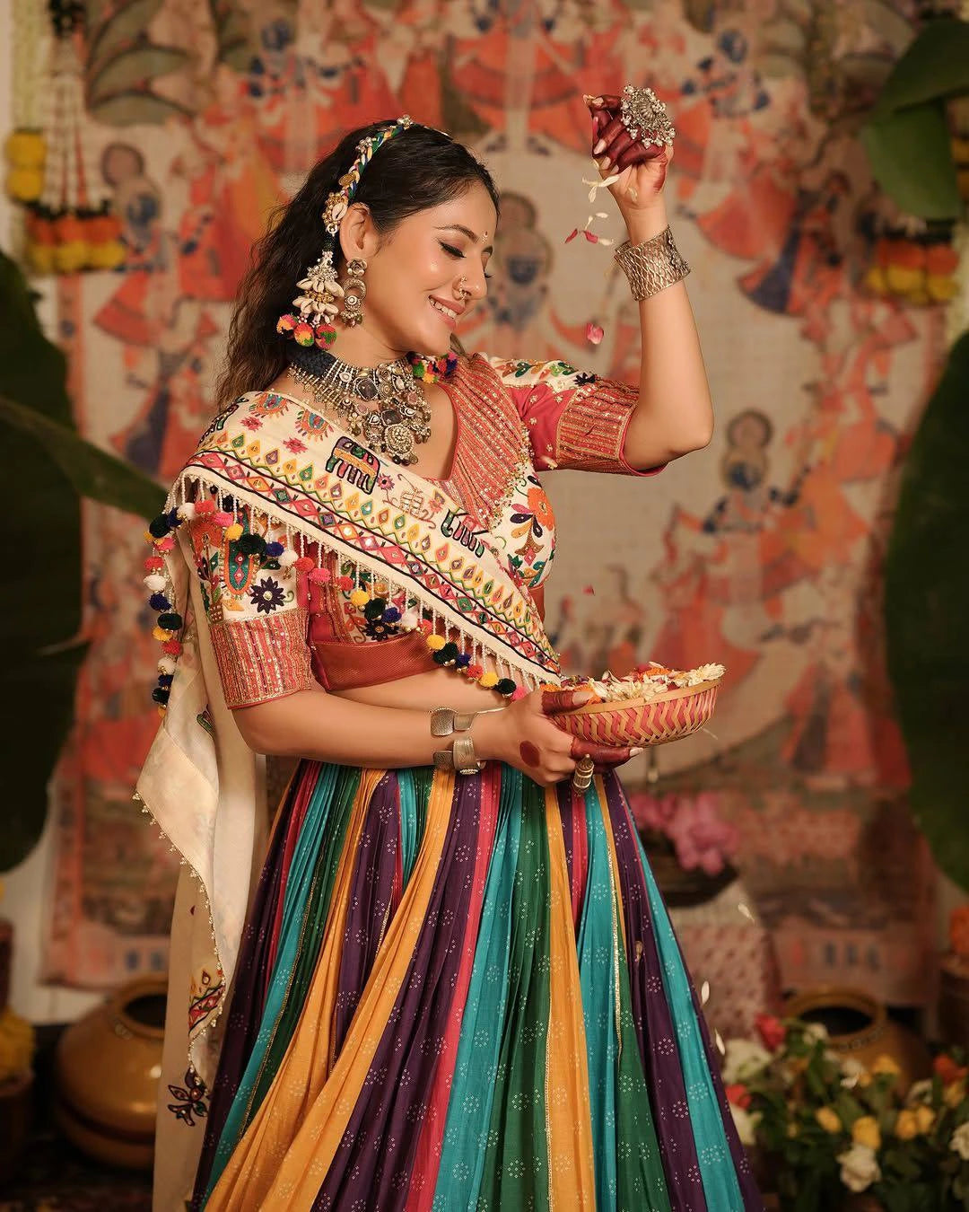 Woman in traditional multicolored outfit holding a decorative item against a festive background