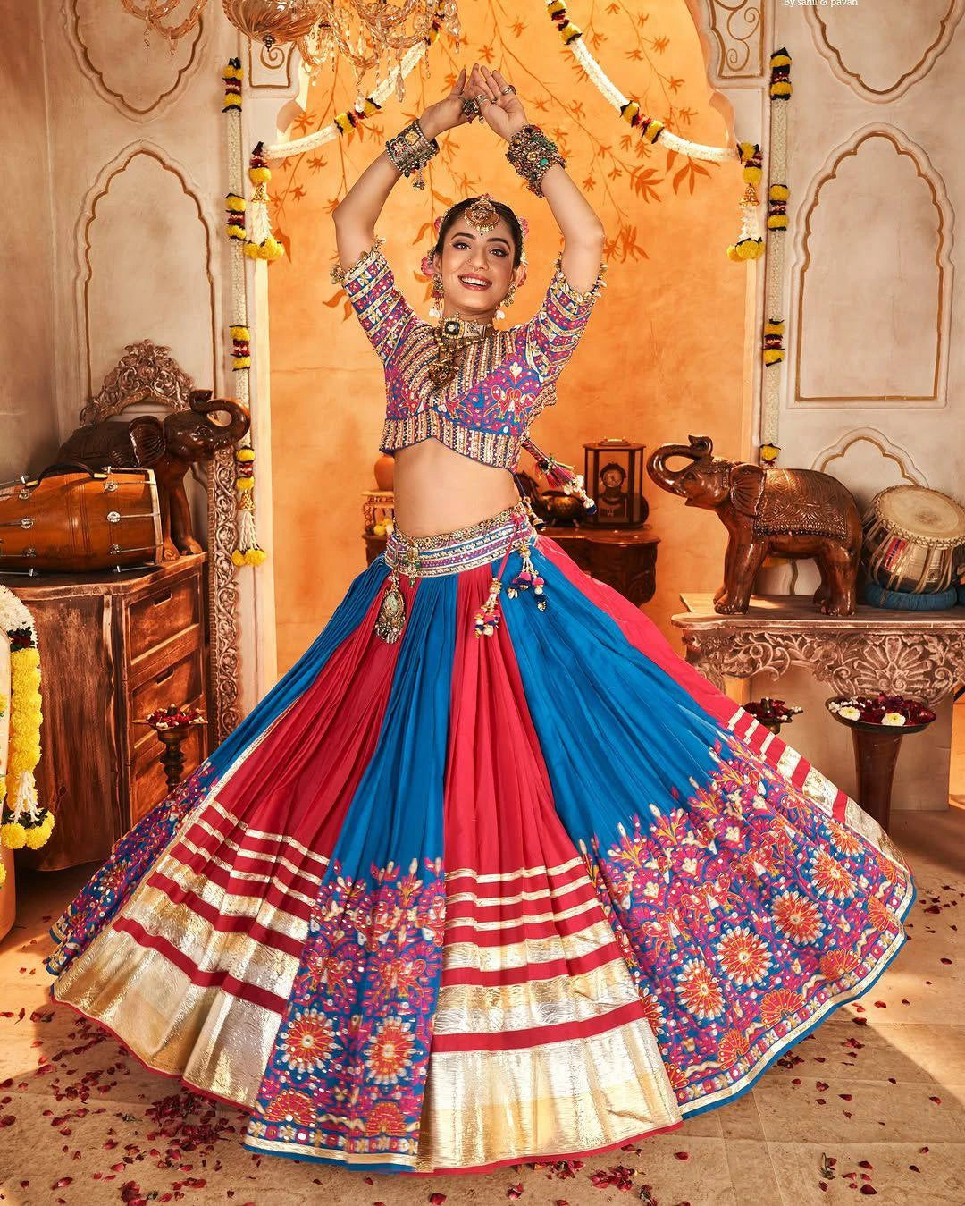 Woman in traditional colorful outfit with floral patterns in a decorated indoor setting