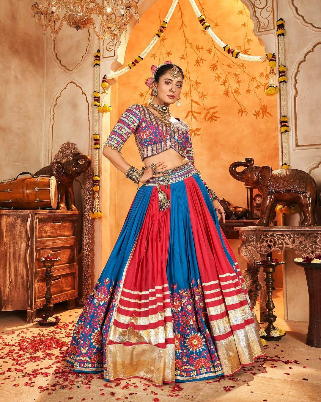 Woman in traditional Indian attire with a colorful saree in a decorated room.