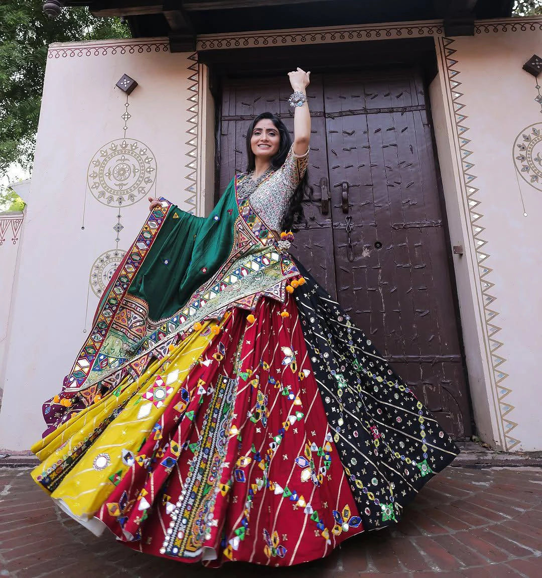 Woman in a colorful traditional outfit standing in front of a decorative door.