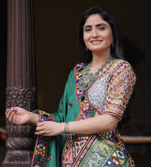 Woman in traditional multicolored outfit with jewelry against a dark background