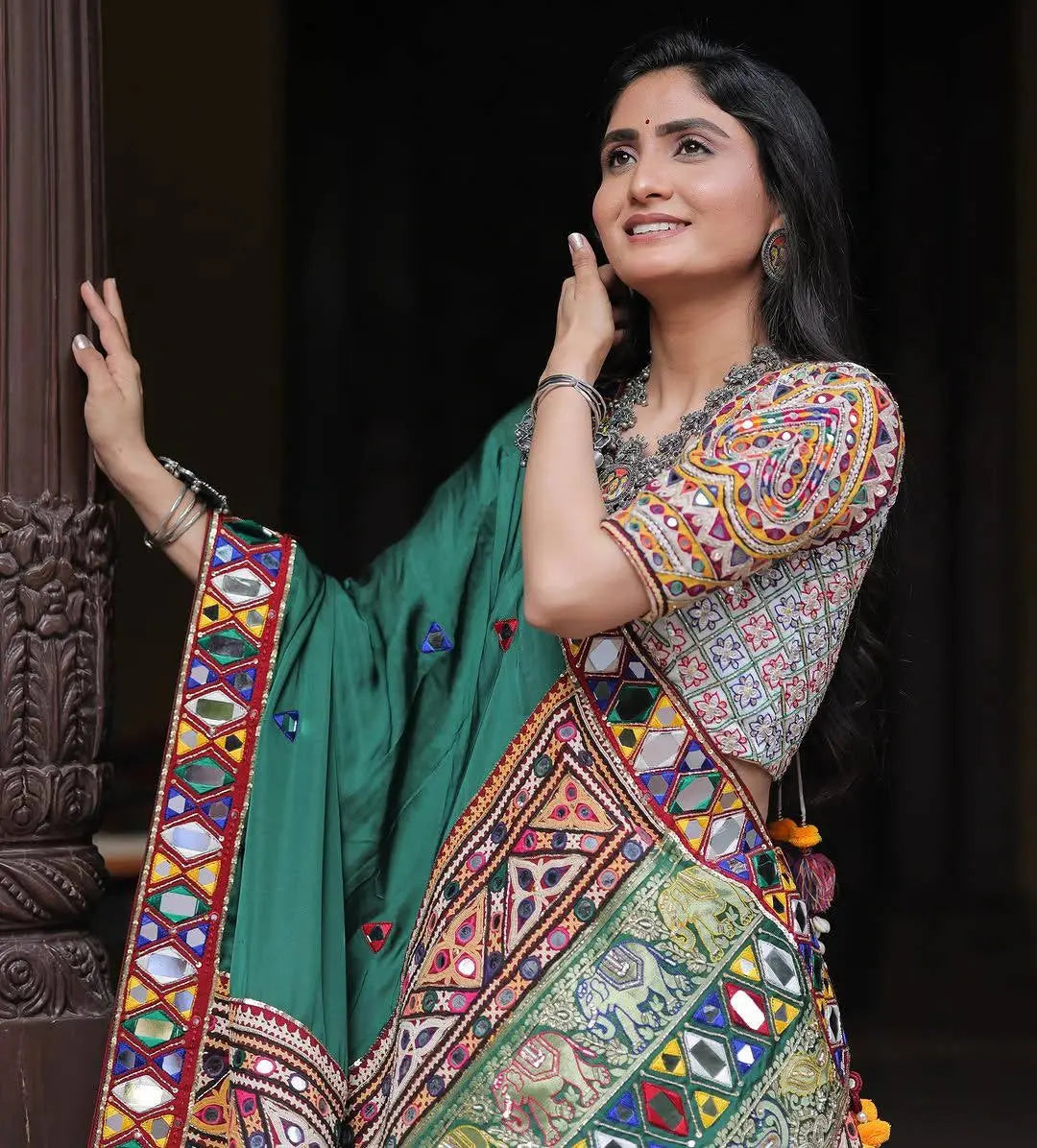Woman wearing a colorful traditional outfit with a green background