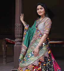 Woman in a colorful traditional outfit standing against a dark background