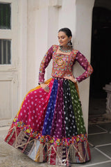 Woman wearing a colorful traditional outfit with a patterned top and multicolored skirt.