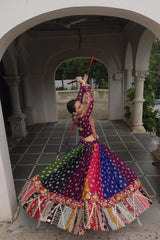 Dancer in a colorful traditional outfit performing in an archway.