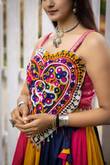 Woman wearing a colorful traditional outfit with intricate patterns.