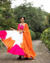 Woman in a colorful saree standing on a pathway with greenery in the background