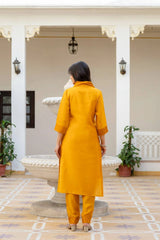 Person wearing a mustard yellow kurta with pants in an indoor setting.