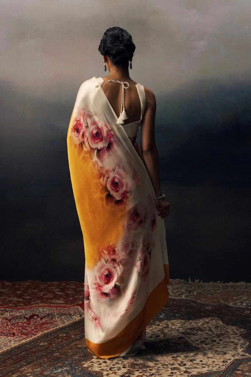 Woman wearing a floral saree with a dark background