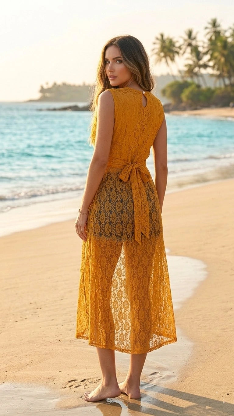 Woman in a yellow dress standing on a beach with palm trees in the background