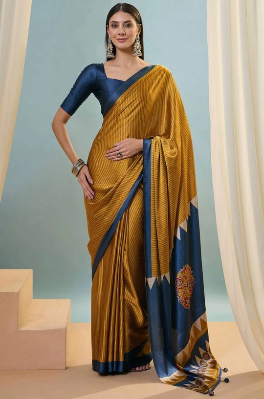 Woman wearing a mustard yellow saree with blue border against a light blue background