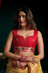 Woman wearing a red blouse with a yellow saree against a dark background