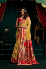 Woman wearing a yellow and red saree with a dark background