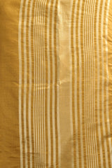 Close-up of gold fabric with thin white stripes