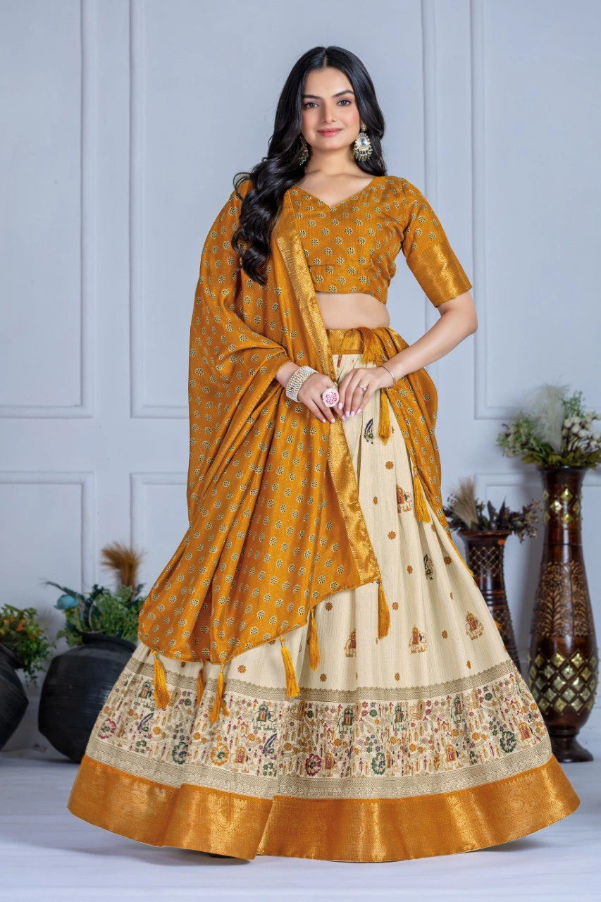 Woman wearing a traditional mustard yellow and white saree with a matching blouse against a light gray wall.