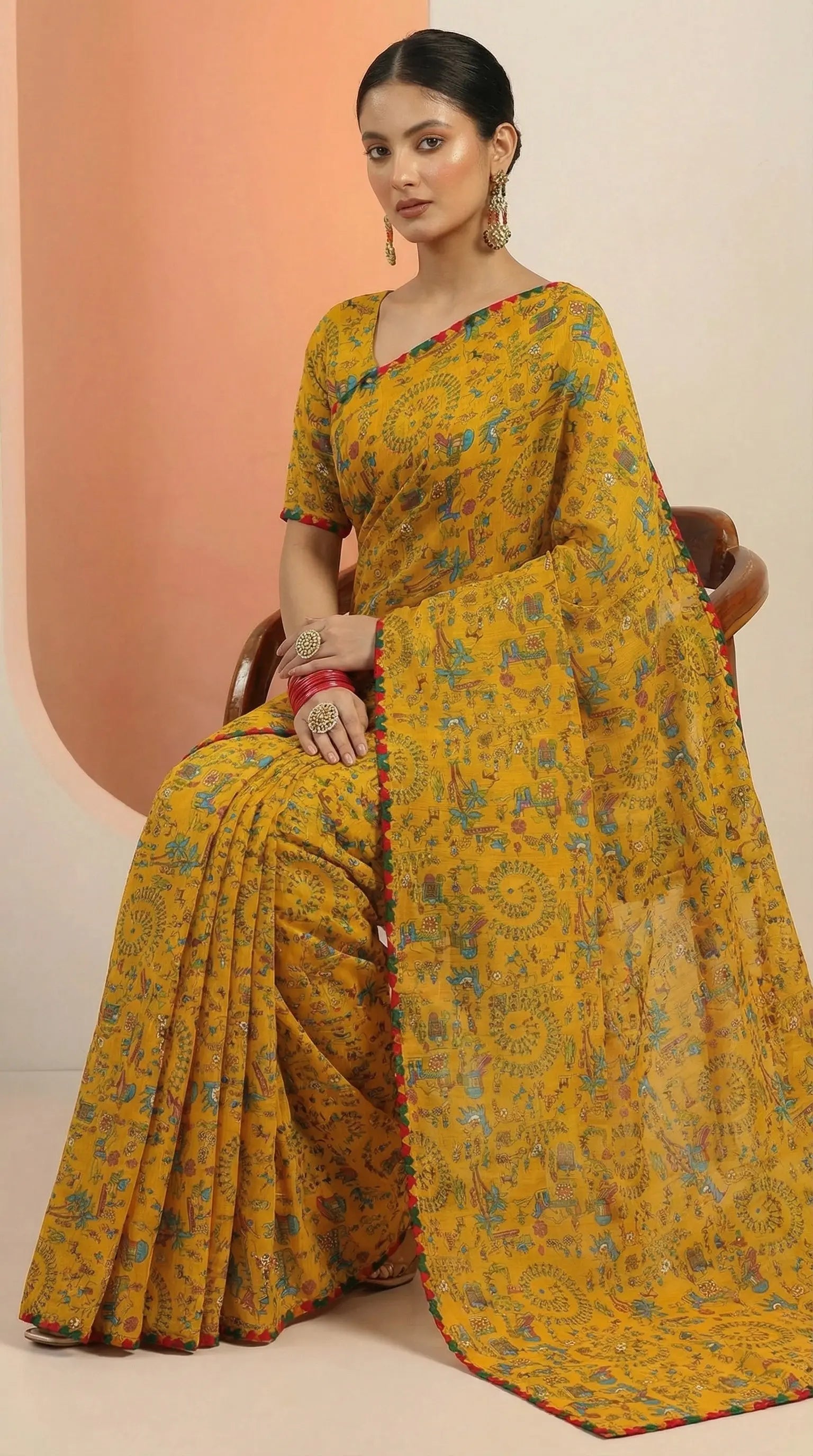 Woman wearing a yellow saree with a pattern on a beige background