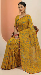 Woman wearing a yellow saree with a pattern on a beige background