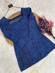 Blue patterned top on a hanger with a white background