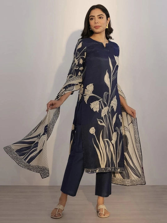 Woman wearing a navy blue outfit with floral patterns against a plain background