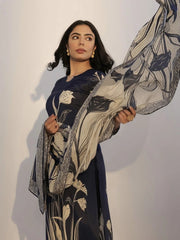 Woman holding a floral-patterned fabric against a plain background