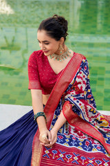 Woman in a colorful saree with a green outdoor background