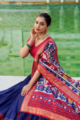 Woman in a colorful saree sitting by a pool