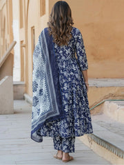 Woman wearing a blue floral dress and dupatta in an outdoor setting.