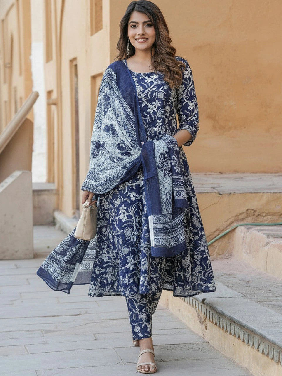 Woman in a blue and white patterned outfit standing outdoors.