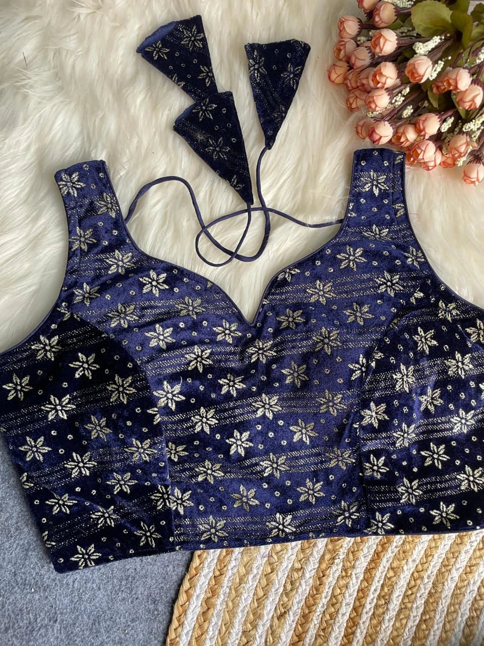 Blue floral patterned lingerie set on a textured surface with flowers.