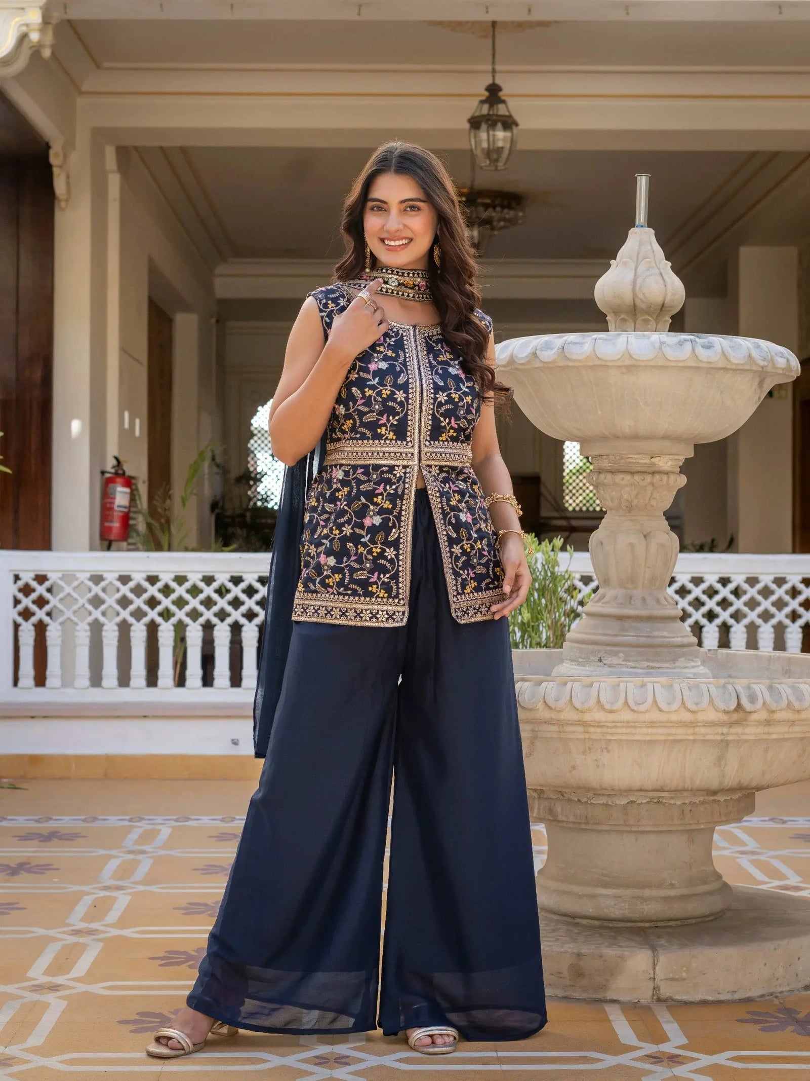 Luxurious navy blue georgette suit folded neatly, showcasing fine embroidery details.