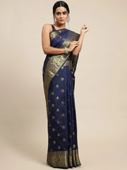 Woman wearing a navy blue saree with gold patterns on a beige background