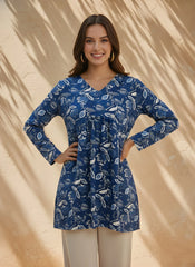 Woman wearing a blue floral dress against a beige background