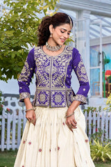 Woman wearing a traditional outfit with a purple top and white skirt in an outdoor setting.