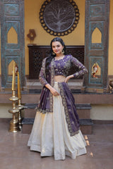 Woman in traditional outfit with purple and white design in a decorated room.
