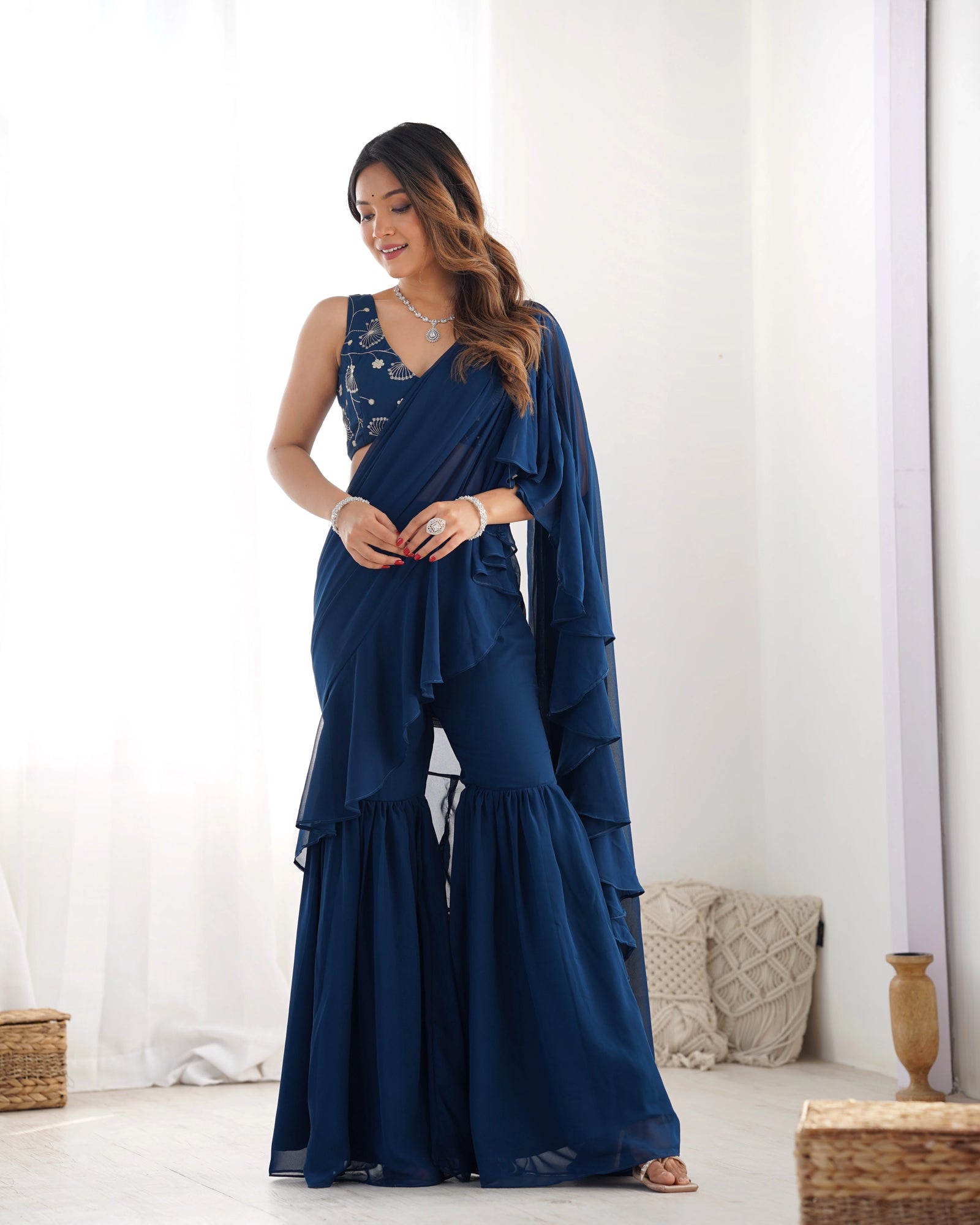 Woman wearing a blue saree with a white background