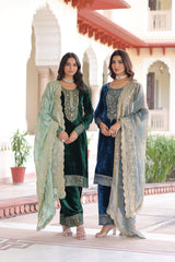 Two women in traditional outfits standing in front of a building with decorative elements.