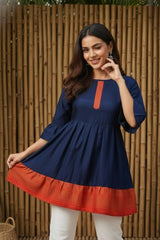 Woman wearing a blue and red dress with a bamboo background