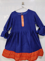 Blue dress with orange bottom section on a hanger against a white background