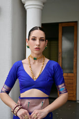 Woman wearing a blue traditional outfit with jewelry in an indoor setting