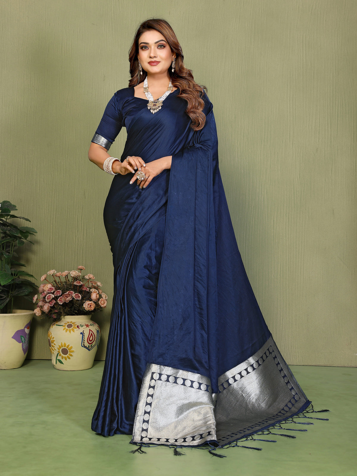 Woman wearing a blue saree with a green background