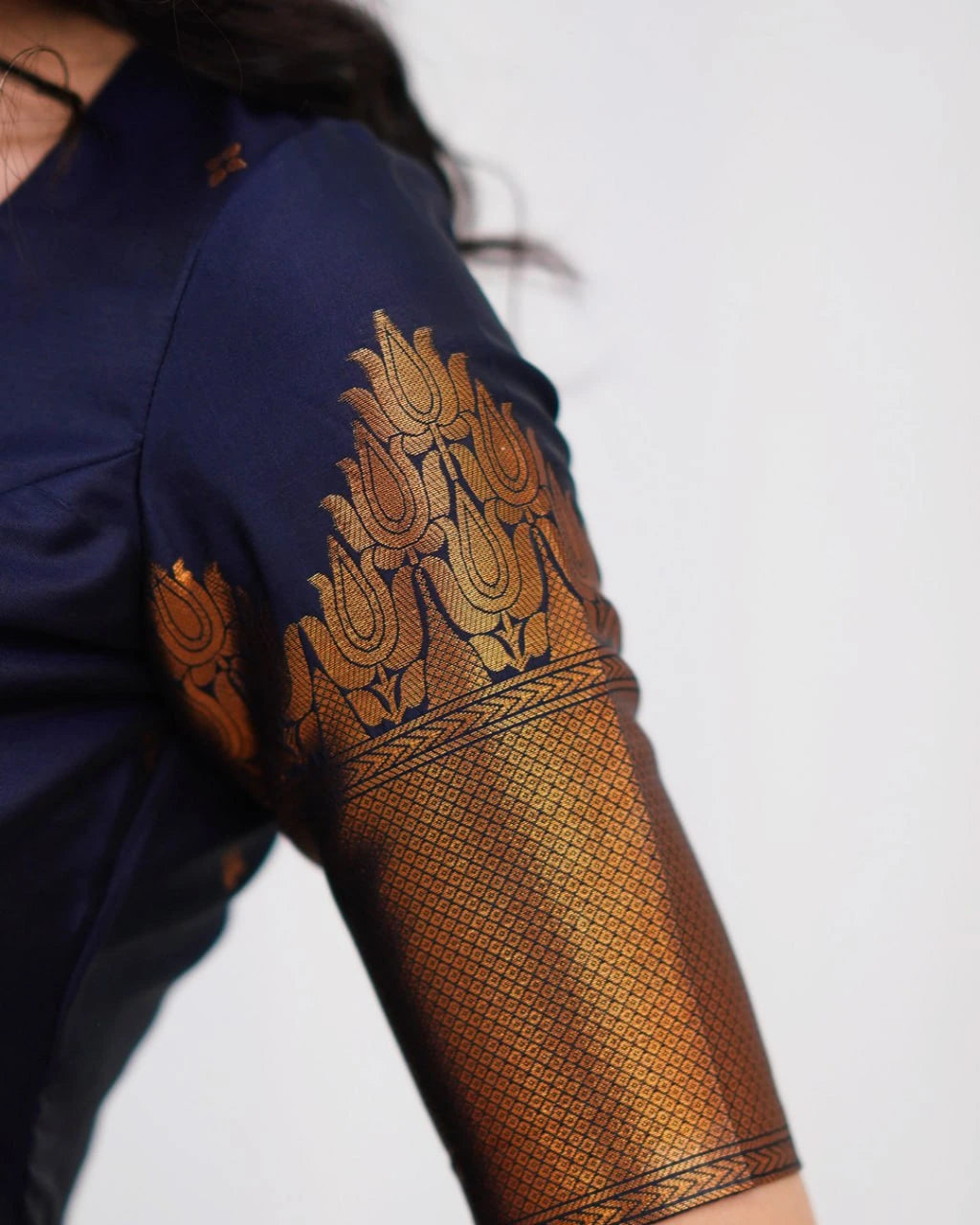 Navy blue garment with gold embroidery on a plain background
