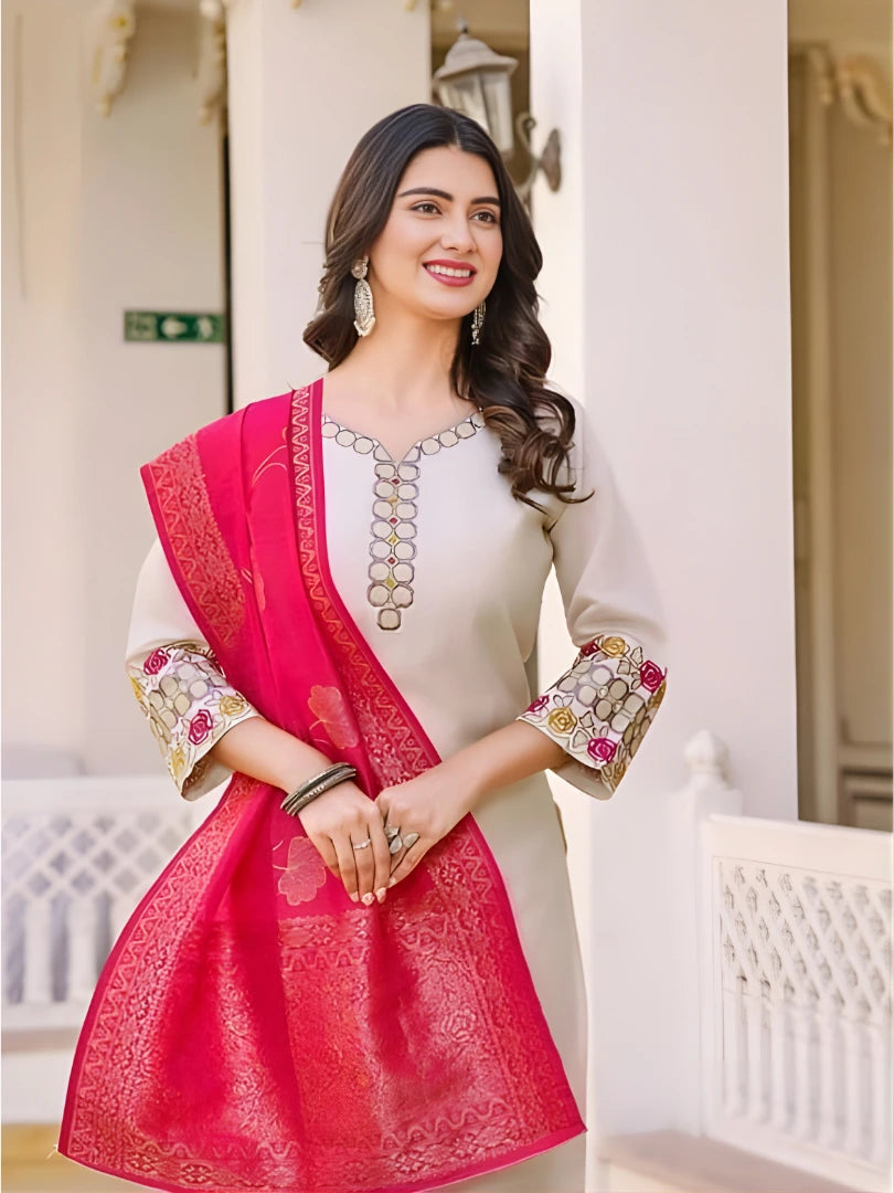 Woman wearing a white and pink traditional outfit with intricate designs.