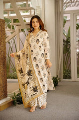 Woman in a floral outfit standing in an indoor setting with plants and a staircase.