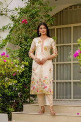 Woman in a floral kurta standing on steps with greenery and a building in the background