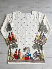 White long-sleeve top with colorful printed design on a gray wooden surface